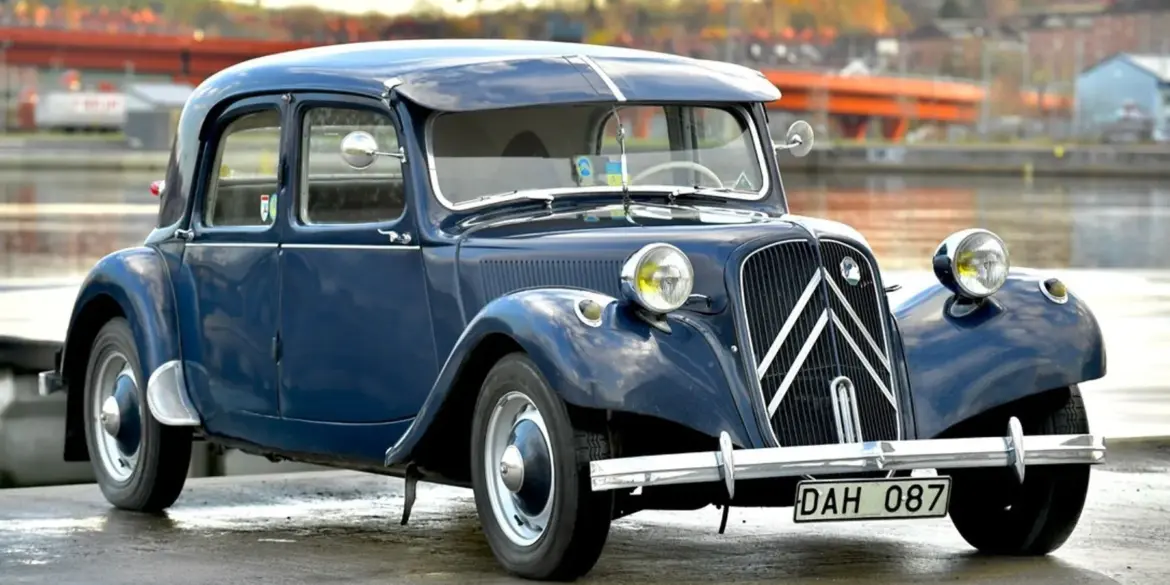 Citroën B11 Traction Avant von 1956 in dunkelblauer Lackierung, aufgenommen an einem Gewässer.