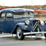 Citroën B11 Traction Avant von 1956 in dunkelblauer Lackierung, aufgenommen an einem Gewässer.
