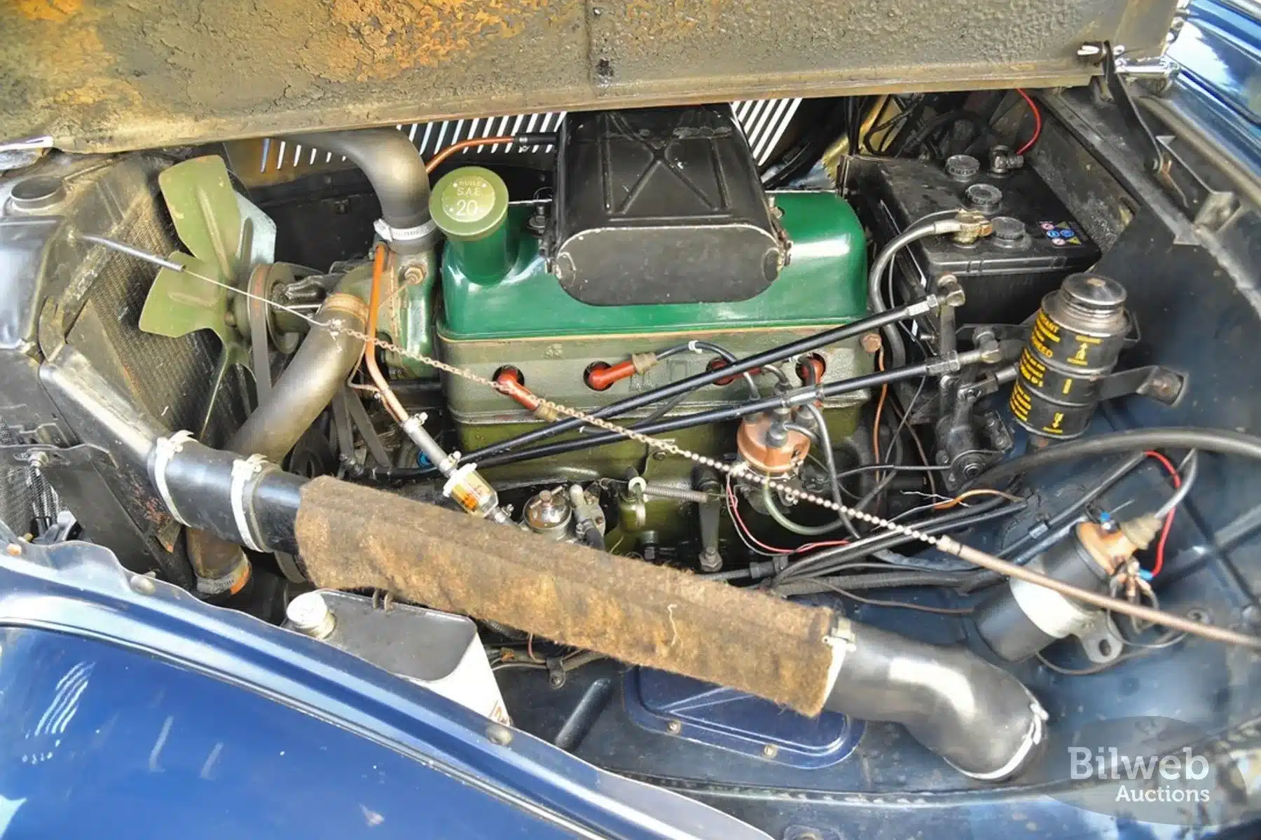 Detailaufnahme des überholten Motors im Citroën B11 Traction Avant von 1956 unter geöffneter Motorhaube.