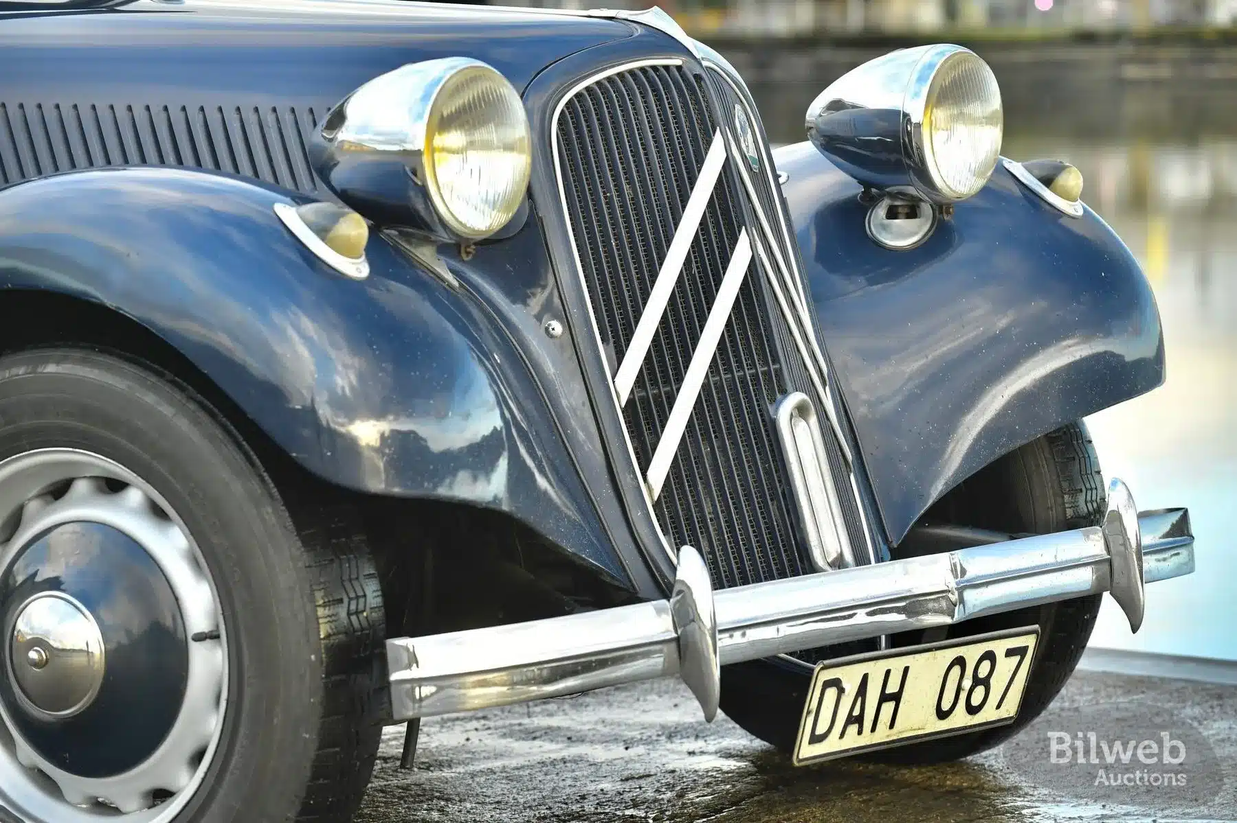Frontpartie eines Citroën B11 Traction Avant, Baujahr 1956, dunkelblauer Lack, Chromdetails, Michelin-X-Reifen und schwedisches Kennzeichen.