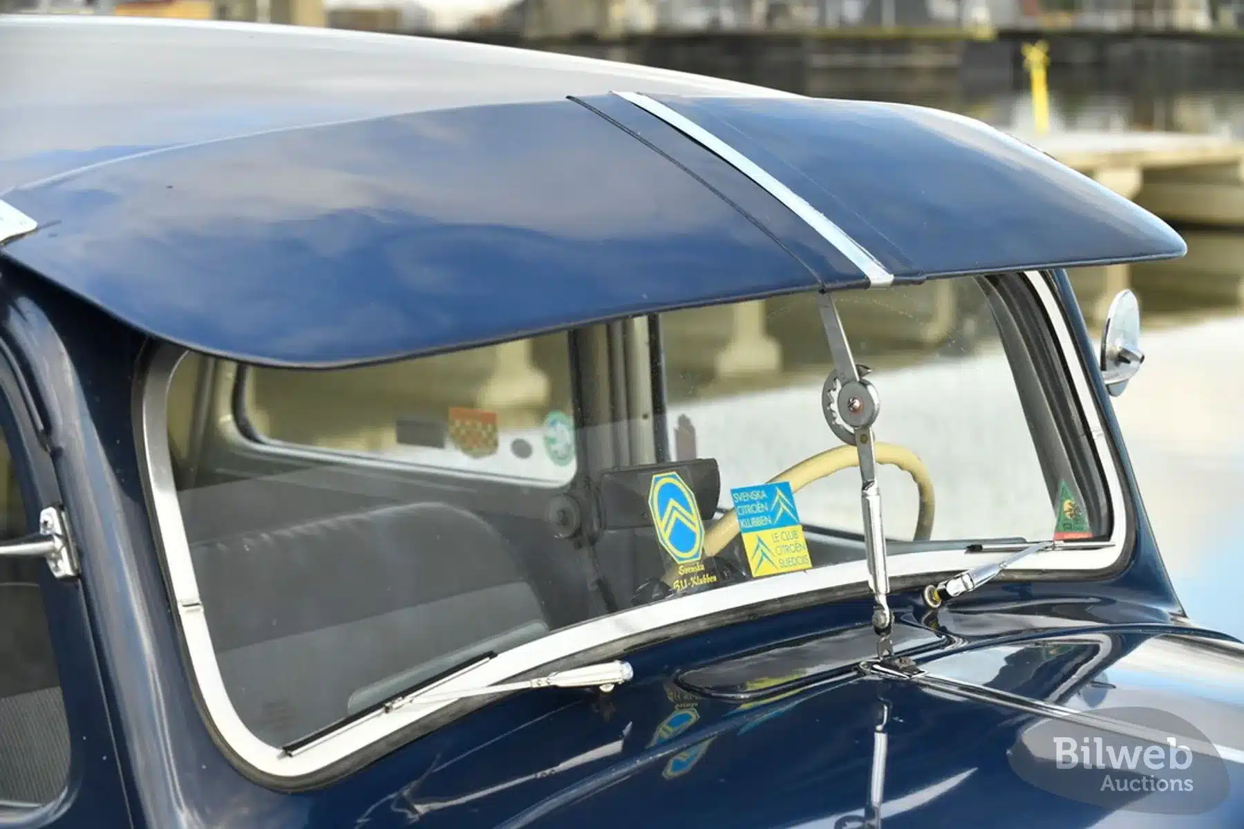 Frontansicht der Windschutzscheibe eines Citroën B11 Traction Avant mit dunkelblauem Lack, Sonnenschutz und sichtbaren Clubabzeichen