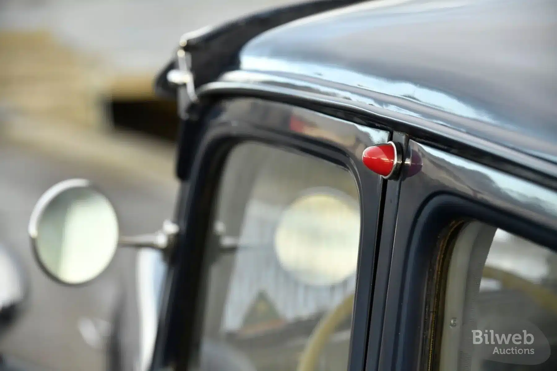 Detailsicht des Blinkers und Spiegels eines Citroën B11 Traction Avant, Baujahr 1956, in dunklem Blauton.