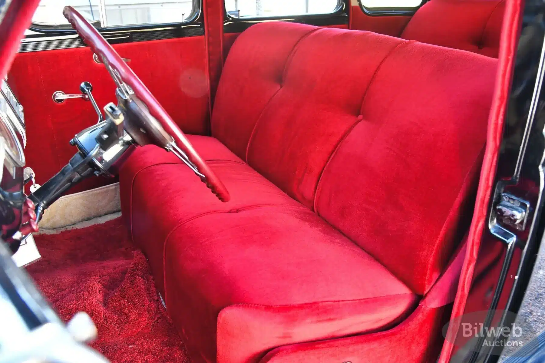 Innenraum eines Dodge Senior Touring Sedan von 1939 mit roter Stoff-Sitzbank und Lenkrad
