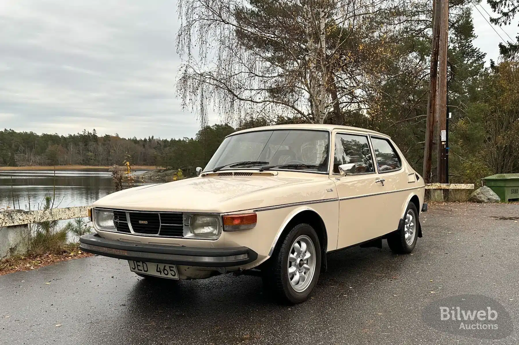 Saab 99 GL von 1976 in hellem Lack, von vorne schräg fotografiert, mit Ronal-Rädern und schwedischem Kennzeichen, geparkt an einem Seeufer