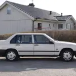 Weißer Volvo 940 Limousine Baujahr 1990, Seitenansicht, originalgetreu
