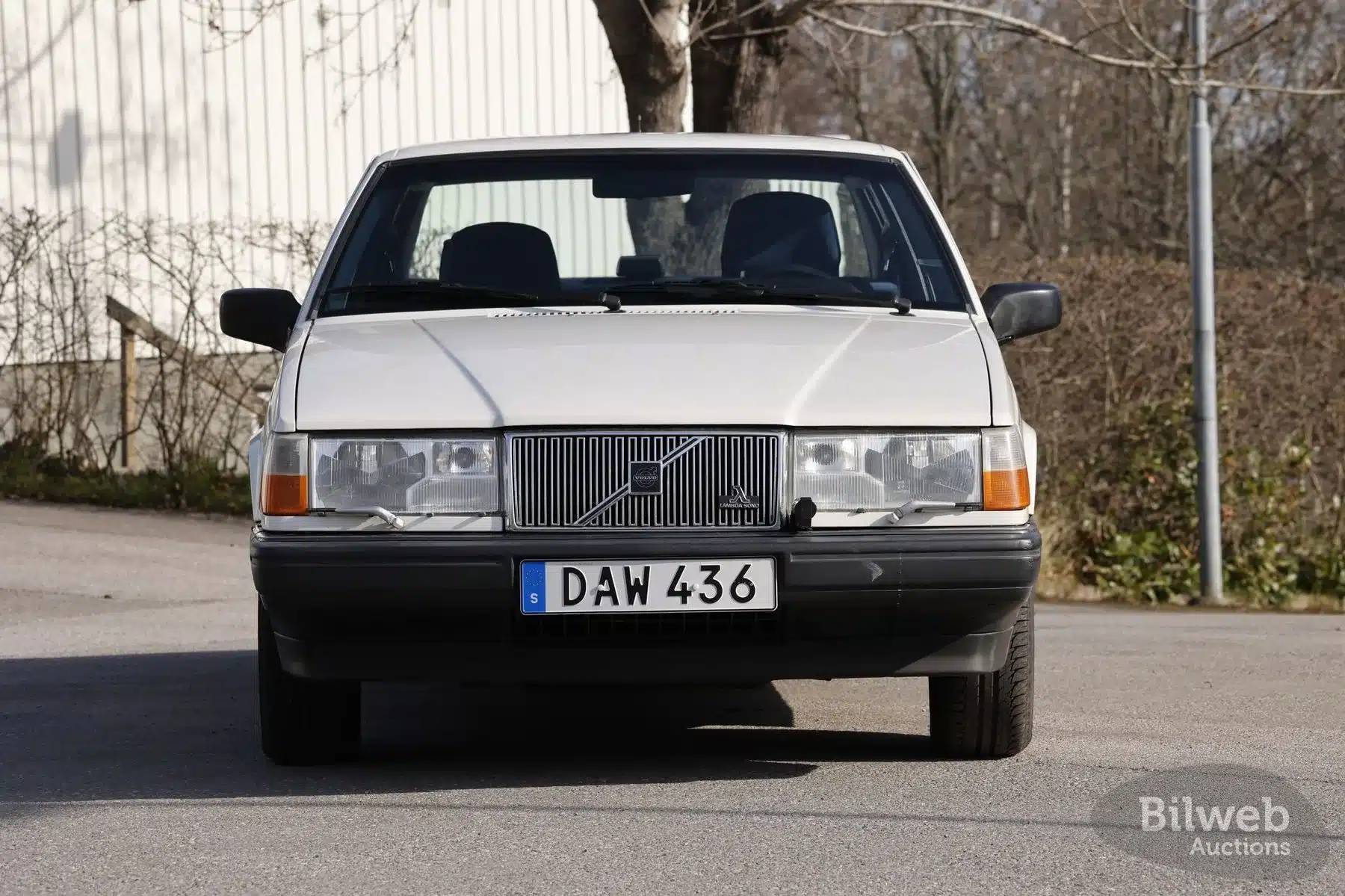 Weiße Volvo 940 Limousine, Baujahr 1990, aus der Frontperspektive fotografiert.