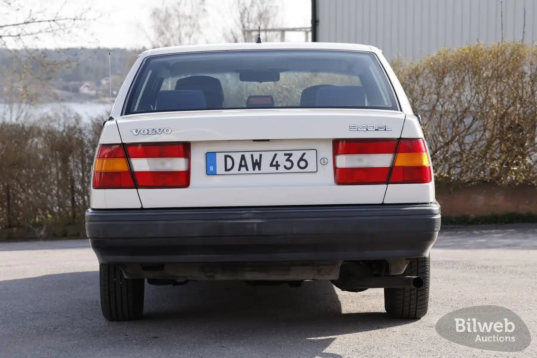 Heckansicht eines weißen Volvo 940 GL mit schwedischem Kennzeichen, Baujahr 1990, geparkt im Freien