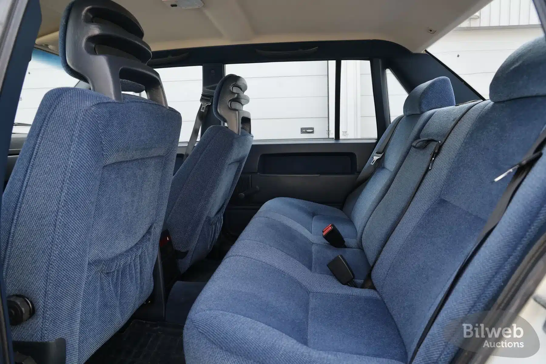 Blauer Stoff-Innenraum mit Rückbank und Vordersitzen eines Volvo 940 von 1990, gepflegter Originalzustand.