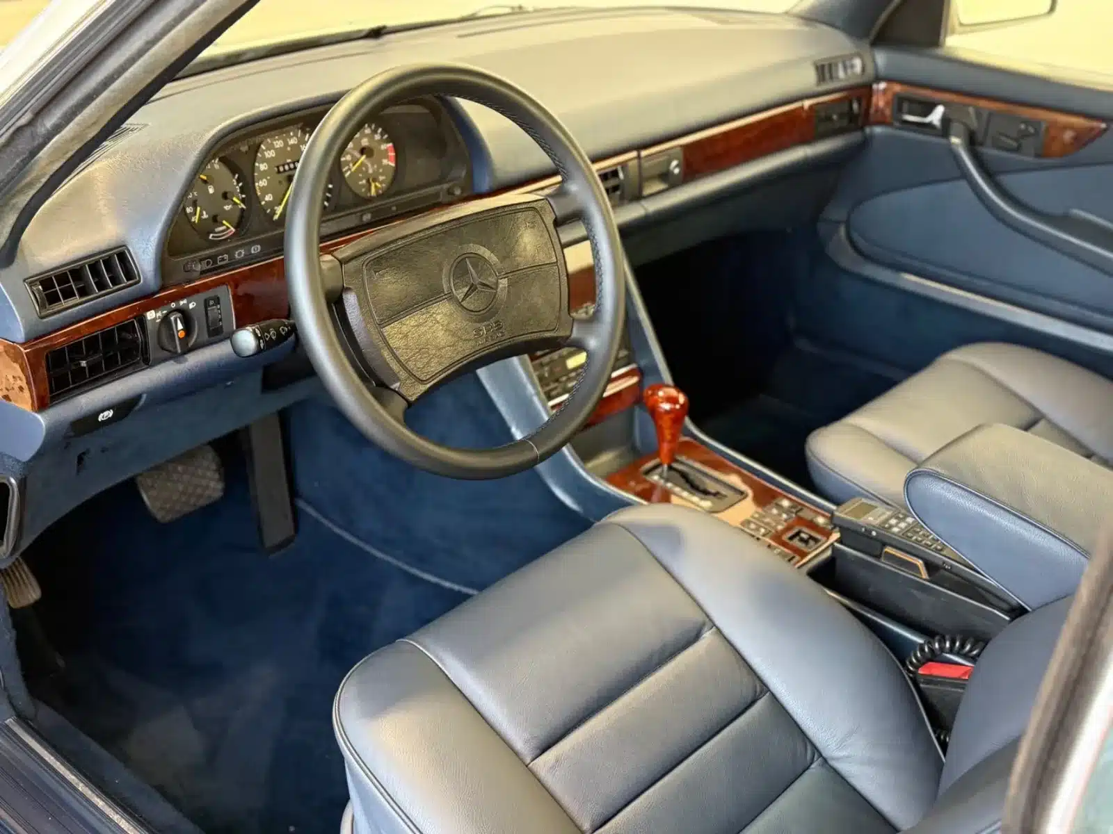 Cockpit und Innenraum eines Mercedes-Benz 500 SEC, blaues Leder und Holzapplikationen
