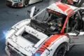 Detailaufnahme des ferngesteuerten Audi R8 LMS GT3 Modells mit sichtbarer Technik und Rennfahrzeug im Hintergrund