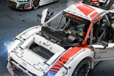 Detailaufnahme des ferngesteuerten Audi R8 LMS GT3 Modells mit sichtbarer Technik und Rennfahrzeug im Hintergrund