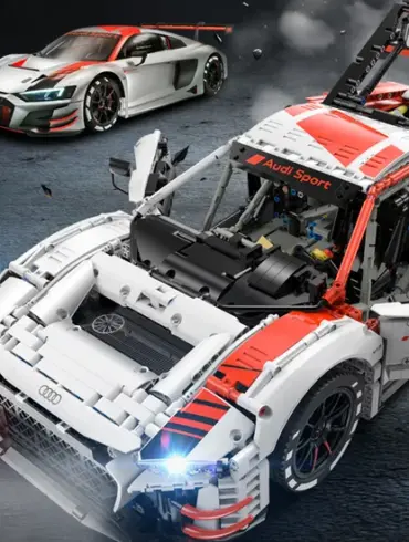 Detailaufnahme des ferngesteuerten Audi R8 LMS GT3 Modells mit sichtbarer Technik und Rennfahrzeug im Hintergrund
