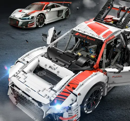 Detailaufnahme des ferngesteuerten Audi R8 LMS GT3 Modells mit sichtbarer Technik und Rennfahrzeug im Hintergrund