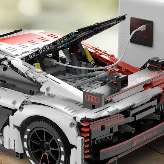 Detailaufnahme des Audi R8 LMS GT3 Modellbau-Kits mit geöffneter Heckklappe, sichtbarer Technik und angeschlossenem Ladekabel.