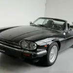Schwarzer Jaguar XJS V12 2+2 Cabriolet mit Arden-Alufelgen und geöffnetem Dach im Studio