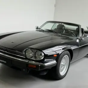 Schwarzer Jaguar XJS V12 2+2 Cabriolet mit Arden-Alufelgen und geöffnetem Dach im Studio
