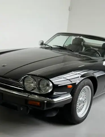 Schwarzer Jaguar XJS V12 2+2 Cabriolet mit Arden-Alufelgen und geöffnetem Dach im Studio