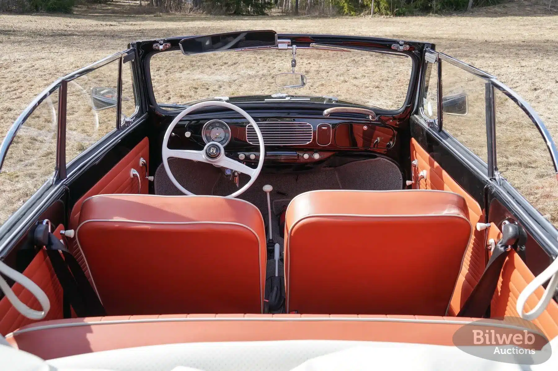 Innenansicht eines Volkswagen Käfer Cabriolet 1200 von 1956 mit rotem Interieur und offener Karosserie.