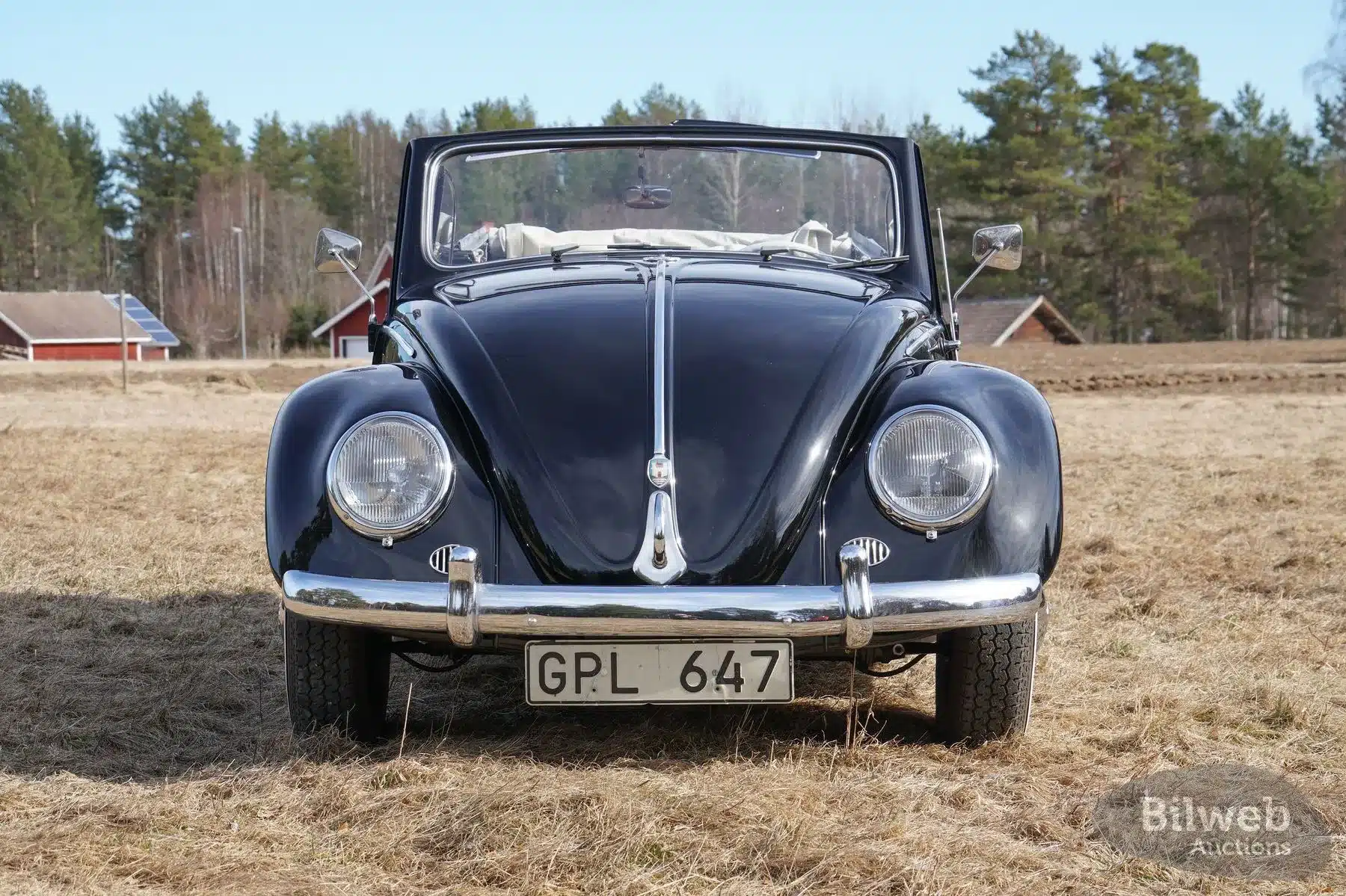 Frontansicht eines schwarzen Volkswagen Käfer Cabriolet 1200 von 1956 mit offenem Verdeck auf einer Wiese, Schweden.