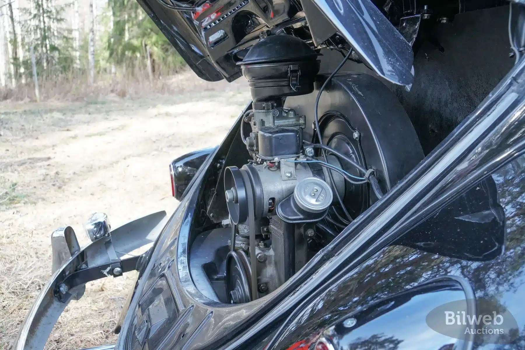 Luftgekühlter Boxermotor eines 1956er VW Käfer 1200 Cabriolet bei geöffneter Motorhaube.