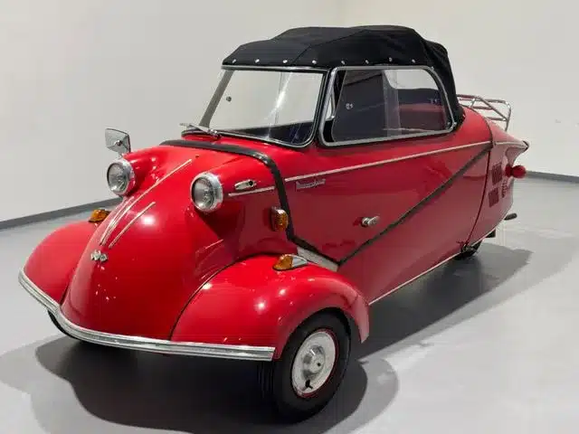 Roter Messerschmitt Kabinenroller Cabriolet mit schwarzem Stoffverdeck in heller Umgebung