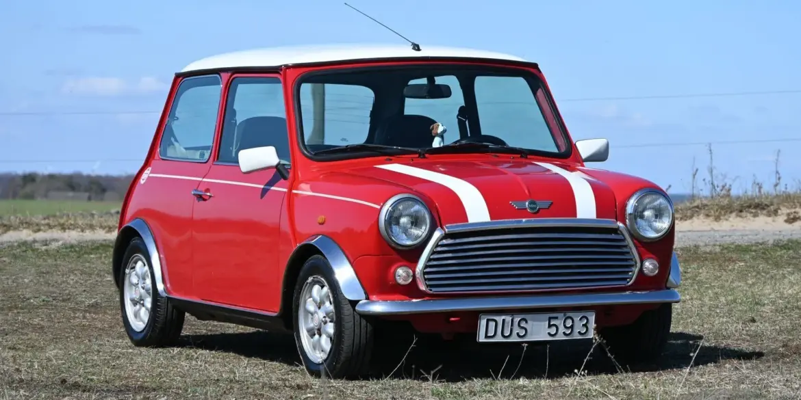 Roter Rover Mini Cooper 1997 mit weißen Streifen, fotografiert im Freien
