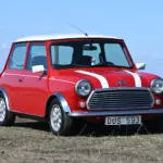 Roter Rover Mini Cooper 1997 mit weißen Streifen, fotografiert im Freien