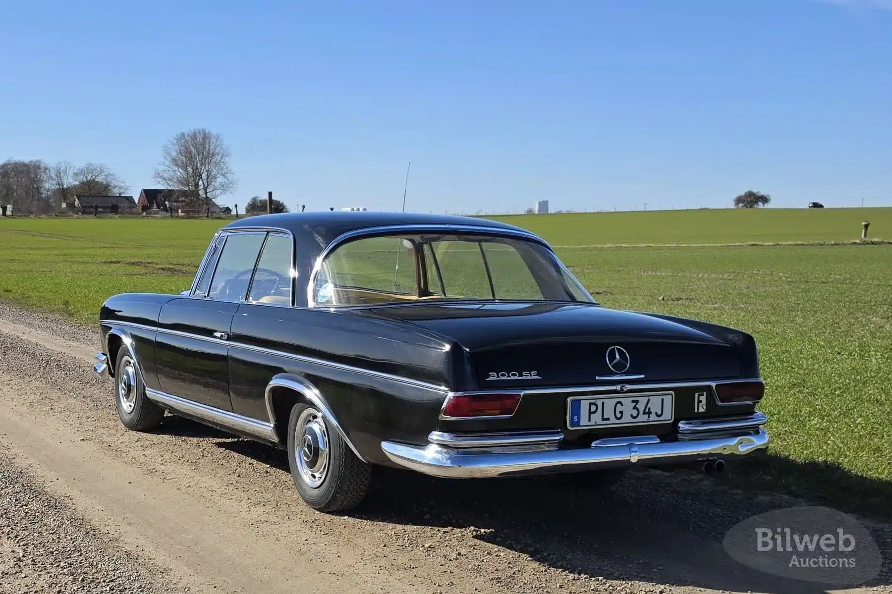 Mercedes-Benz 300 SE Coupé W112 Baujahr 1964, schwarze Karosserie, Heckansicht auf Feldweg bei Sonnenschein