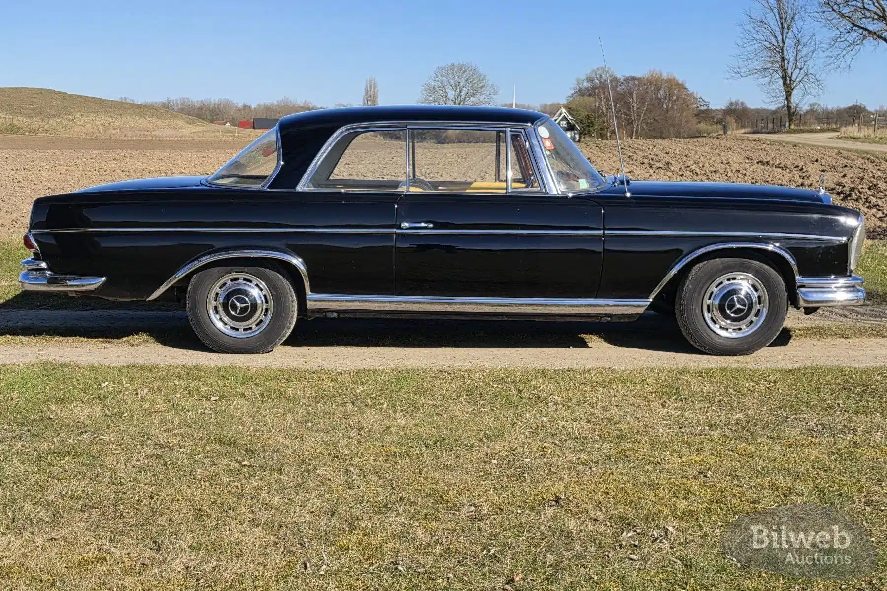 Mercedes-Benz 300 SE Coupé W112, Baujahr 1964, schwarze Lackierung, Seitenansicht auf dem Land.