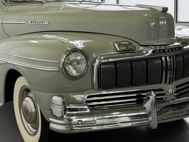 Detailaufnahme der Frontpartie eines Mercury Eight V8 Oldtimers mit großem Chromgrill und charakteristischer Haube.
