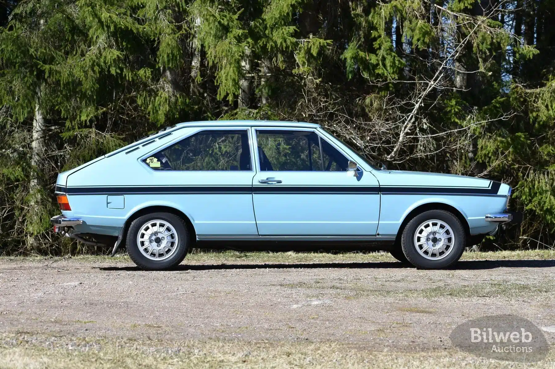 VW Passat TS 1500 von 1974 in Himmelblau, Seitenansicht, Originalzustand, Klassiker vor Waldkulisse.