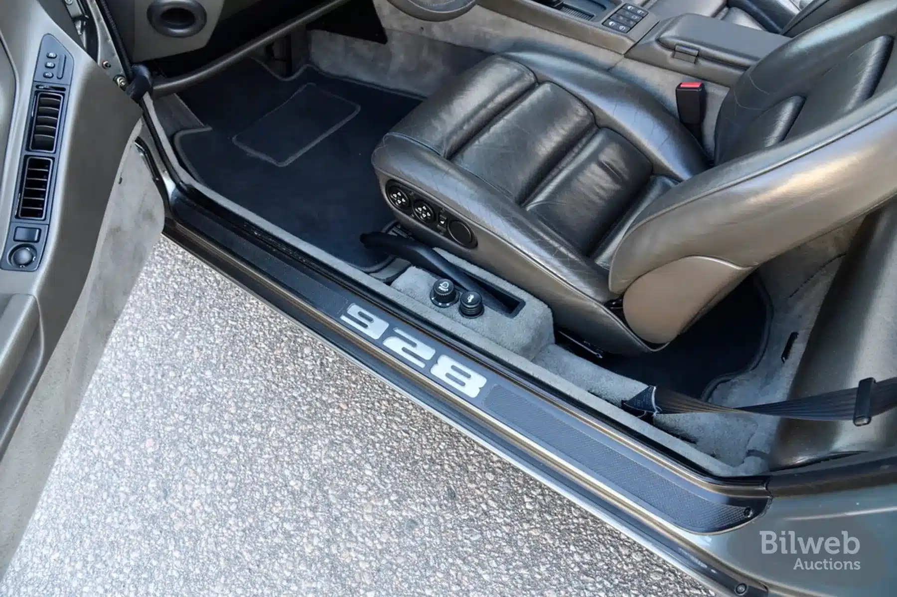 Innenraum und Einstiegsbereich eines Porsche 928 S4, Baujahr 1988, mit schwarzen Ledersitzen und sichtbarer 928-Einstiegsleiste.