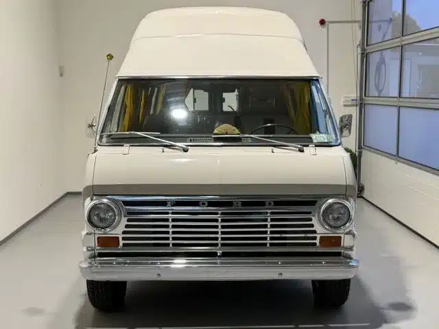 Frontansicht eines weißen Ford Econoline Custom-Minihome-Campervan der 1970er Jahre in einer Garage.