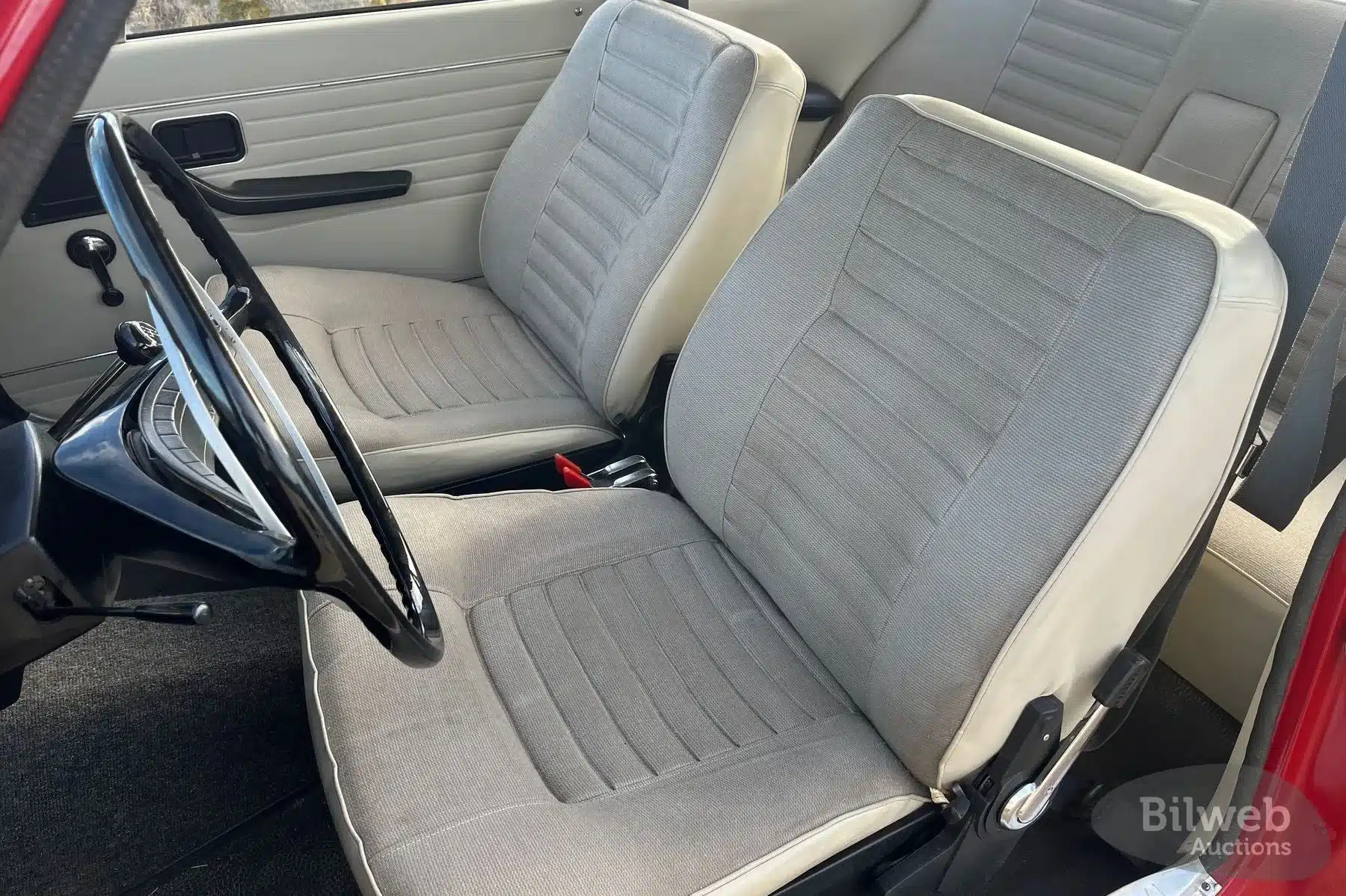 Vordersitze und Armaturenbrett eines Volvo 142 B20 von 1969 mit beigem Stoffinterieur.