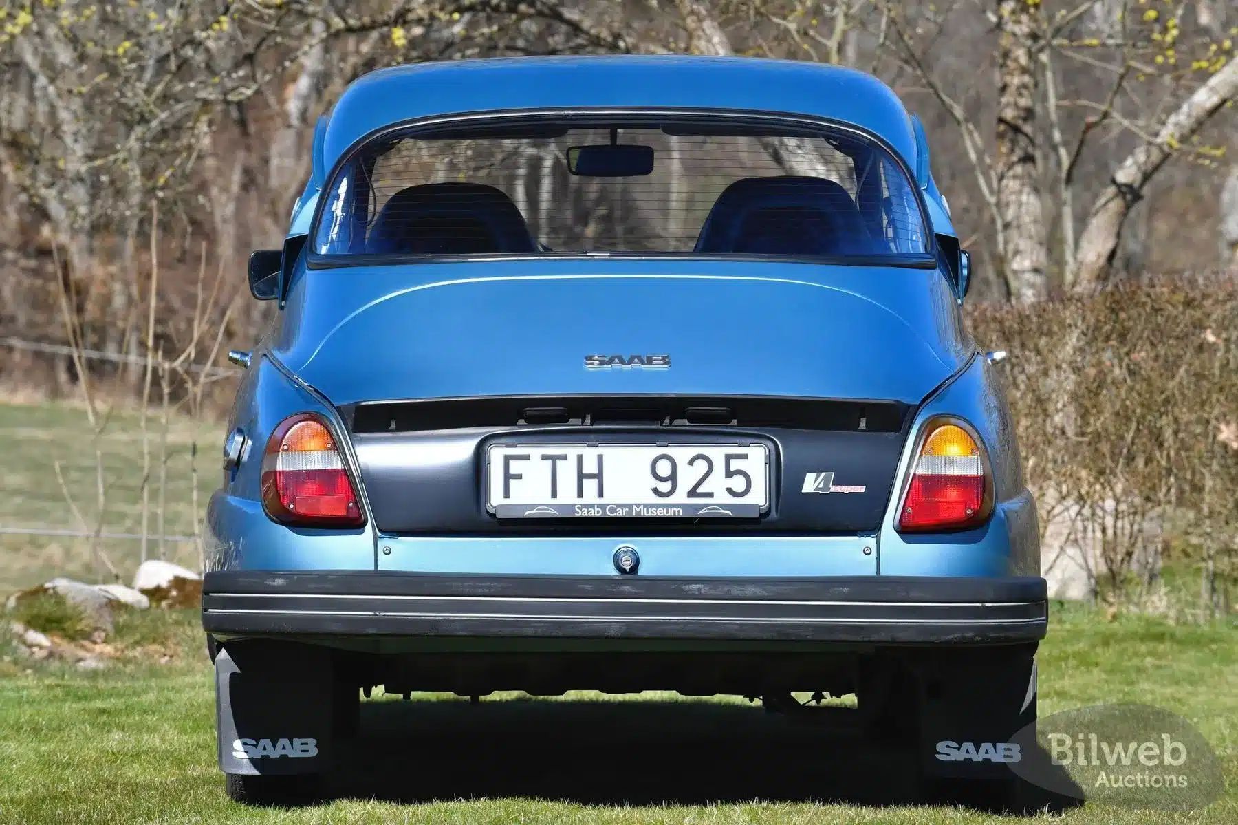 Heckansicht eines blauen Saab 96 Jubileum V4 von 1980 mit schwedischem Nummernschild und V4-Emblem.