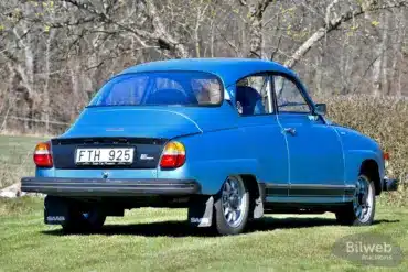 Saab 96 Jubileum V4 Baujahr 1980 in Aquamarine Blue Metallic mit Ronal-Felgen, Heckansicht auf einer Wiese