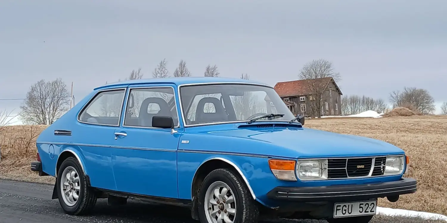 Blauer Saab 99 GL 2,0 von 1977, geparkt an einer Landstraße, Front- und Seitenansicht