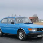 Blauer Saab 99 GL 2,0 von 1977, geparkt an einer Landstraße, Front- und Seitenansicht