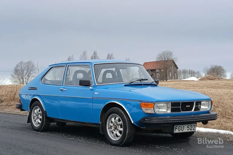 Blauer Saab 99 GL 2,0 von 1977, geparkt an einer Landstraße, Front- und Seitenansicht