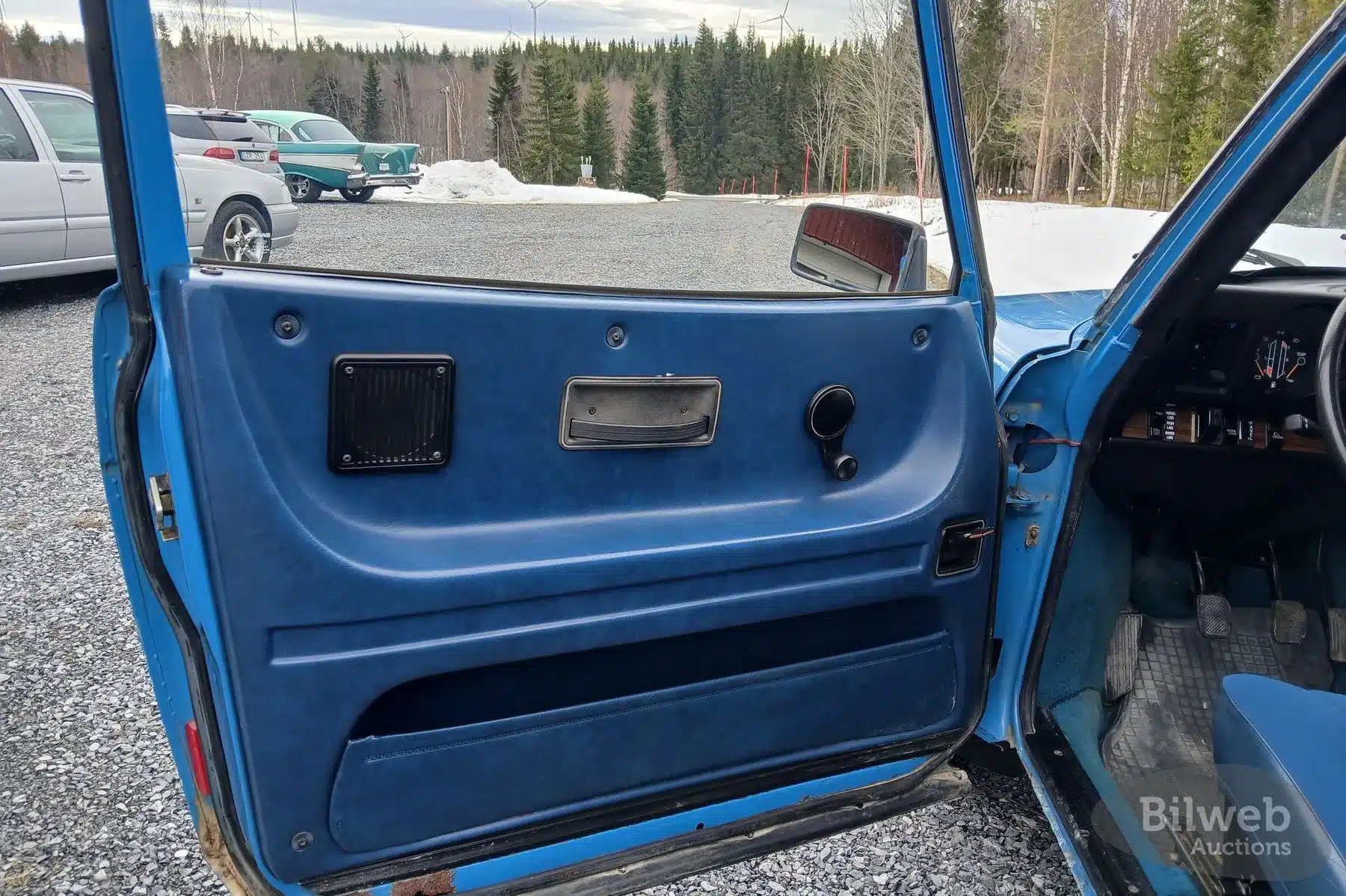 Blaue Türverkleidung und Innenraum eines klassischen Saab 99 GL 2,0, Baujahr 1977, aus Sicht des Fahrers.
