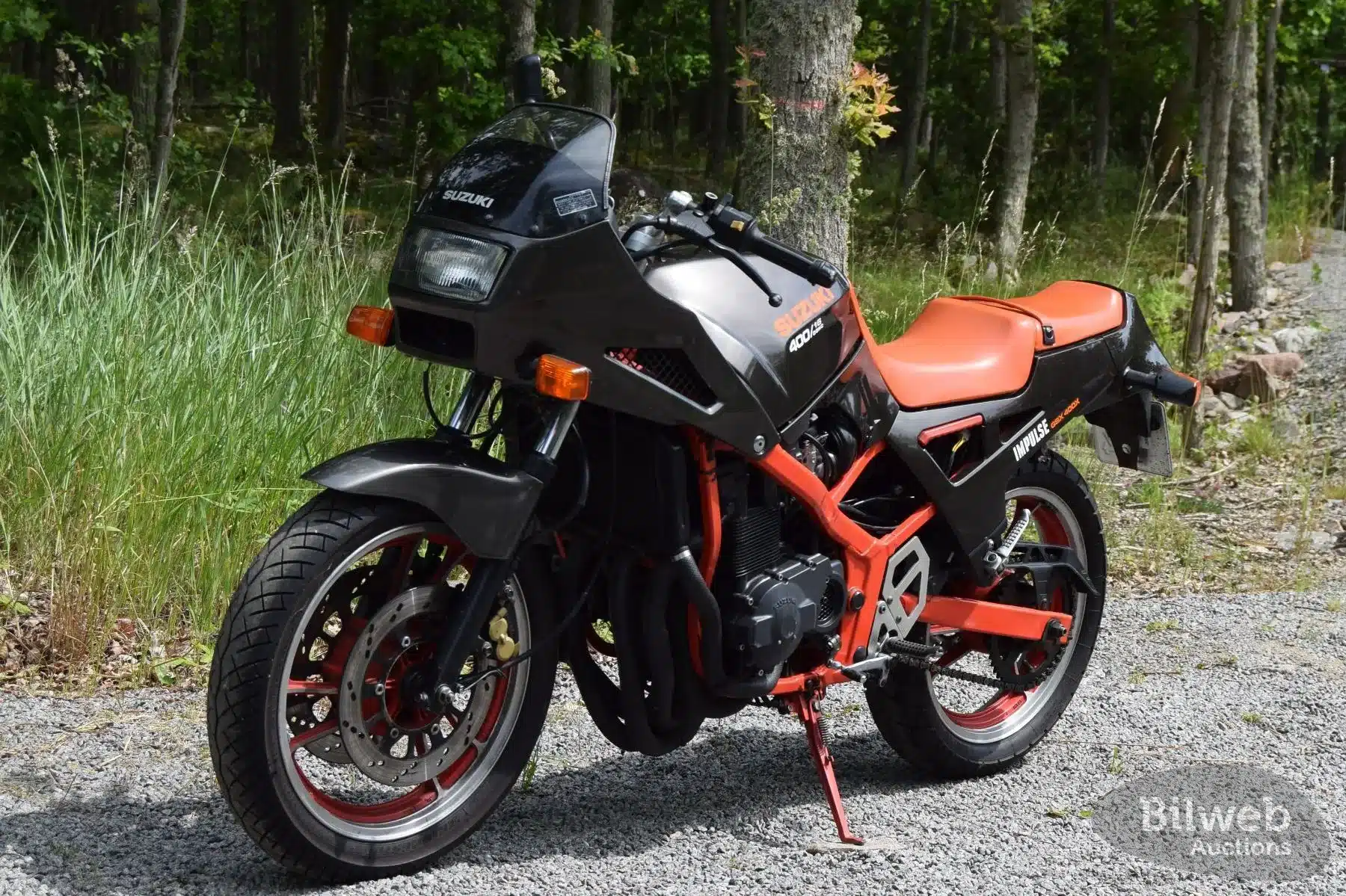 Suzuki GSX 400X Impulse von 1989 in klassischer Schwarz/Rot-Lackierung, abgestellt auf einem Waldweg