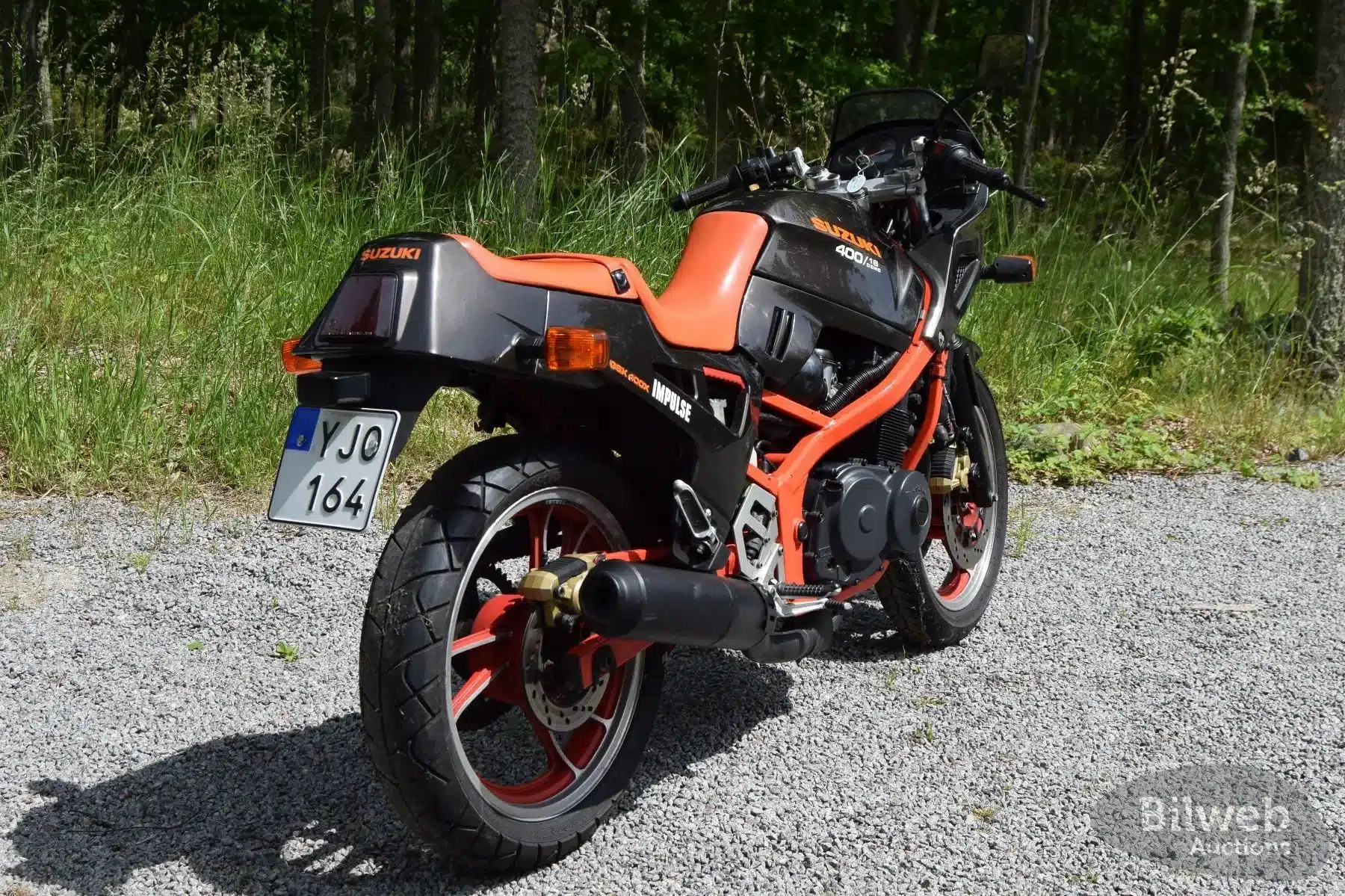 Suzuki GSX 400X Impulse Baujahr 1989 in Schwarz/Rot von hinten, geparkt auf Kiesweg, sichtbares schwedisches Kennzeichen.