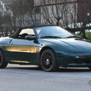 Lotus Elan 1.6 Turbo 16V aus dem Jahr 1991 in Dunkelgrün mit geschlossenem Verdeck und schwarzen Alufelgen, fotografiert im Freien.