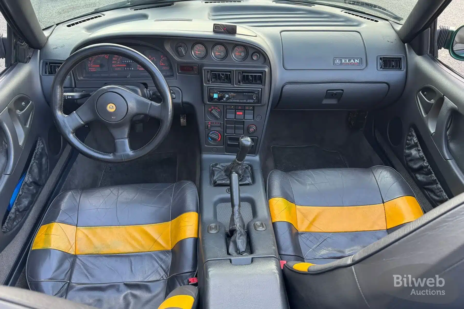 Innenansicht des Lotus Elan M100 1.6 Turbo 16V, Baujahr 1991, mit Blick auf Lenkrad, Armaturenbrett und zweifarbige Ledersitze