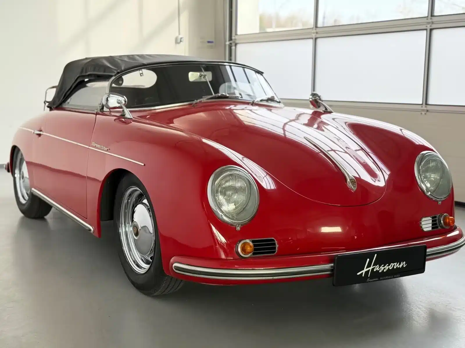 Roter Porsche 356 Speedster Replica von 1992 mit Verdeck, präsentiert in heller Garage.