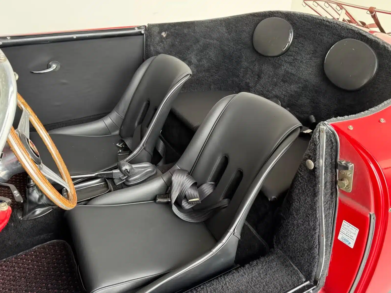 Blick auf die beiden schwarzen Schalensitze, das Holzlenkrad und den Innenraum des Porsche 356 Speedster Replica von 1992