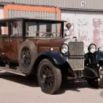 Seitenansicht eines unrestaurierten Mercedes-Benz 320 Mannheim 12/55 PS W04 Baujahr 1928 mit brauner und schwarzer Lackierung, abgenutztem Ersatzrad und matter Oberfläche.