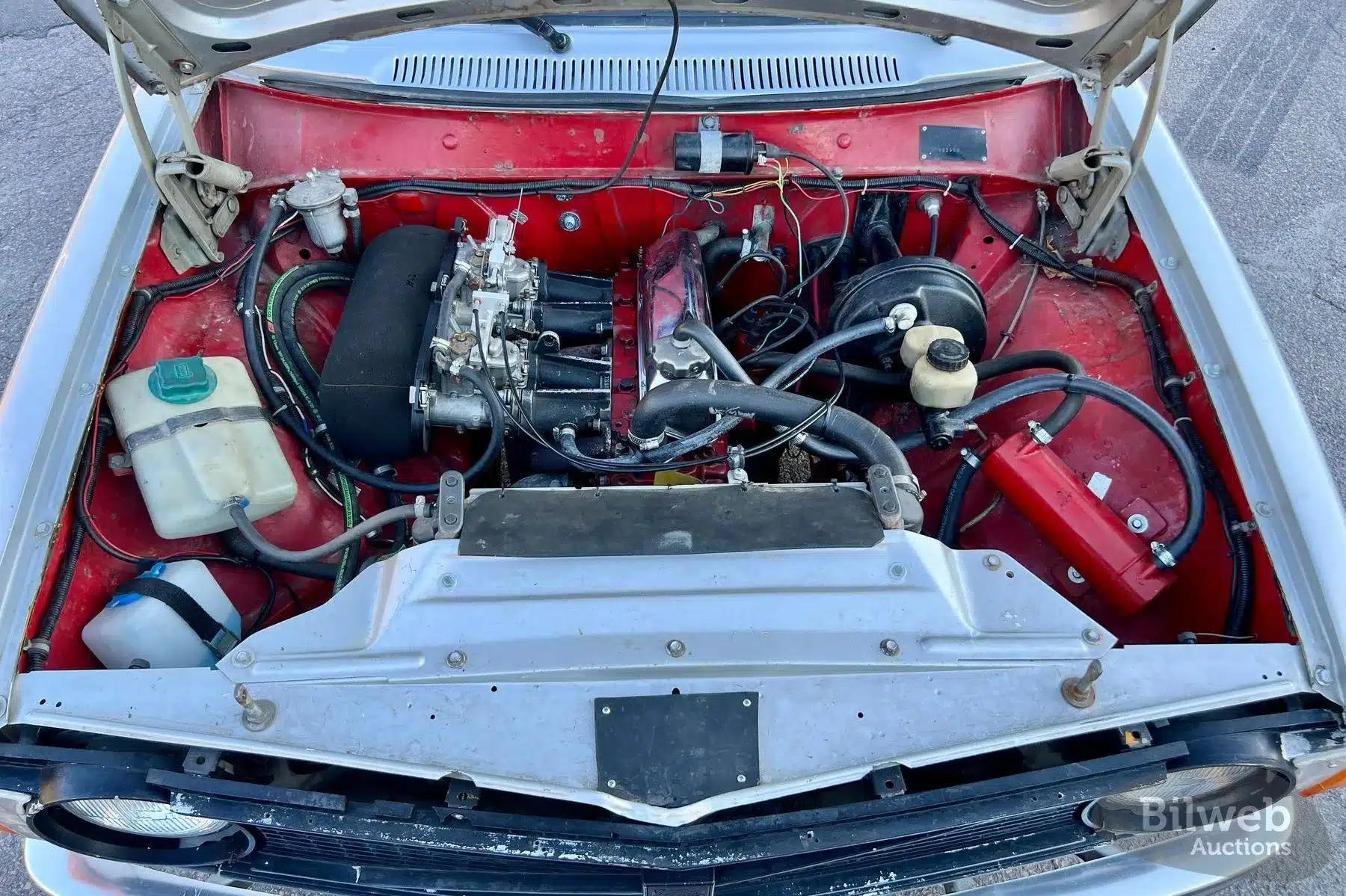 Detailaufnahme des Motorraums eines Volvo 142 Rallyeautos von 1970 mit B20-Motor und Doppelvergasern.