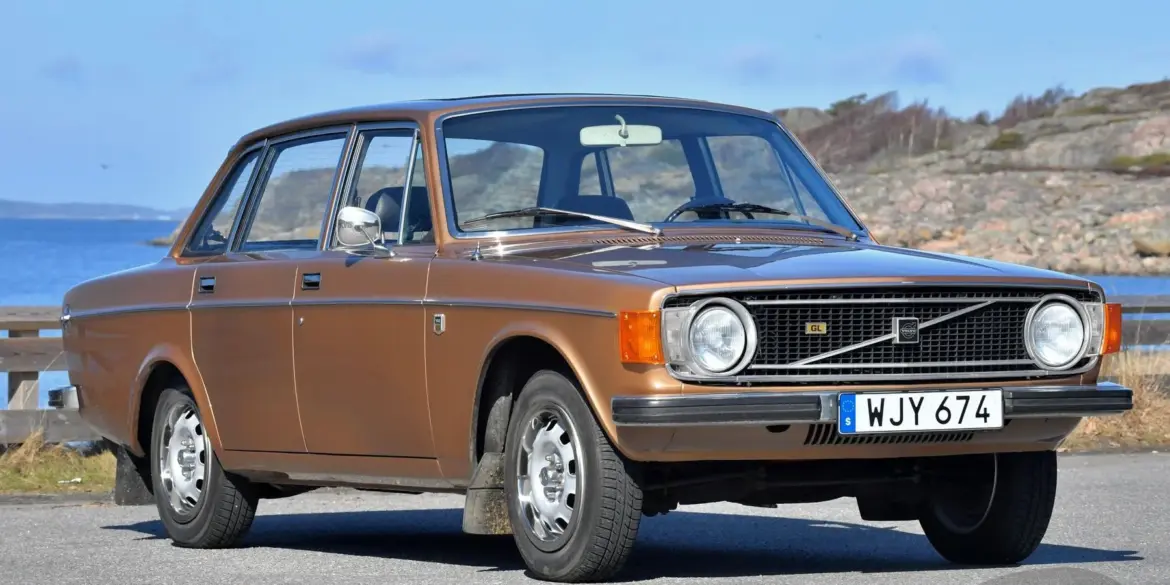 Brauner Volvo 144 GL B20 von 1973 geparkt vor Küstenkulisse