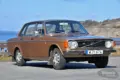 Brauner Volvo 144 GL B20 von 1973 geparkt vor Küstenkulisse